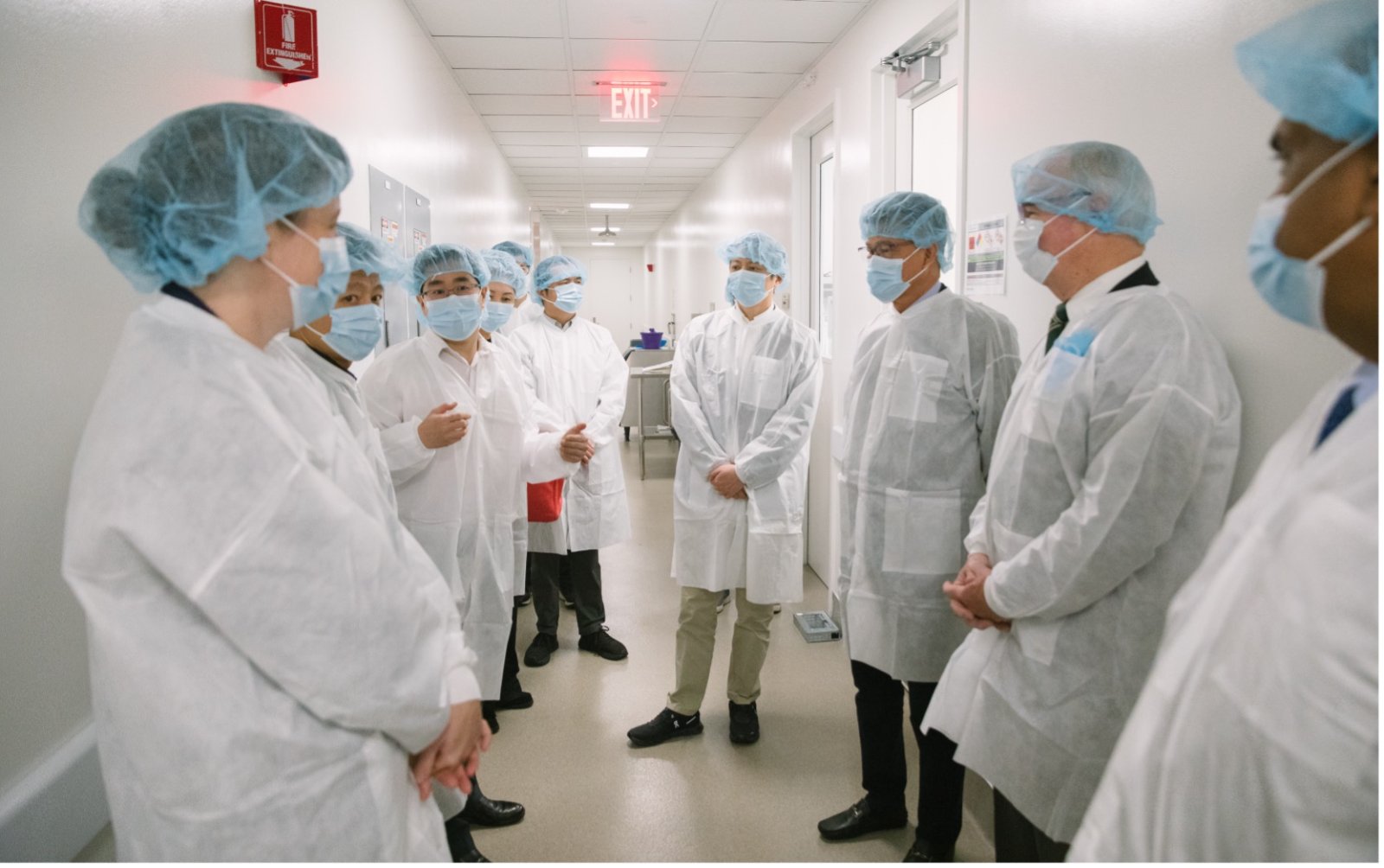 Guests in lab coats touring the ChemPartner laboratory in Watertown, Massachusetts