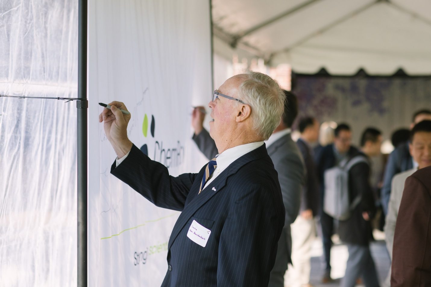 Guest signing the ChemPartner anniversary wall