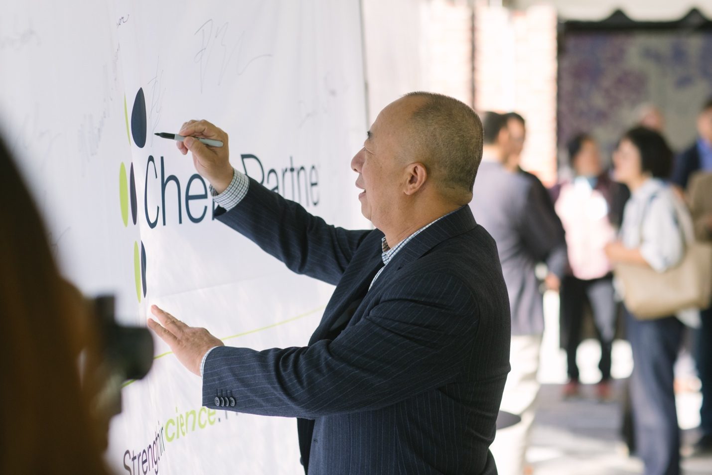 Guest adding a message to the ChemPartner anniversary wall